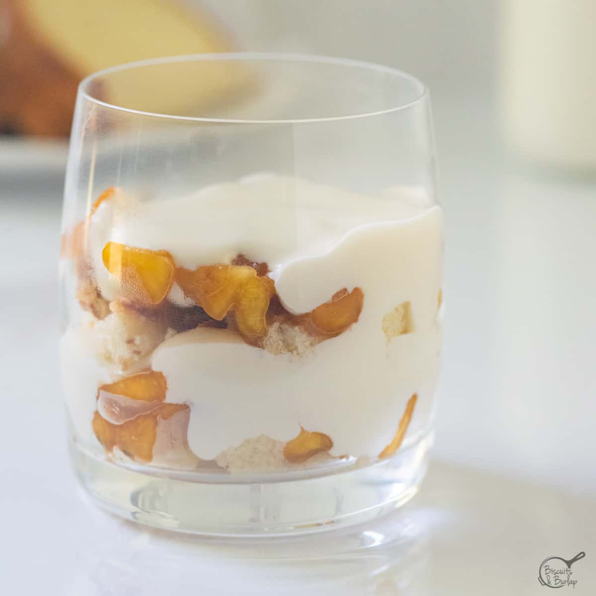 square shot of peach trifle in glass.