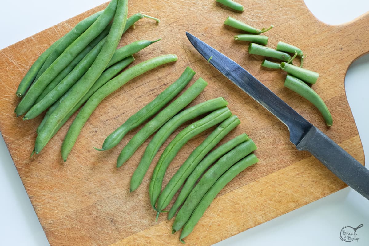 fresh green beans on board with ends trimmed.