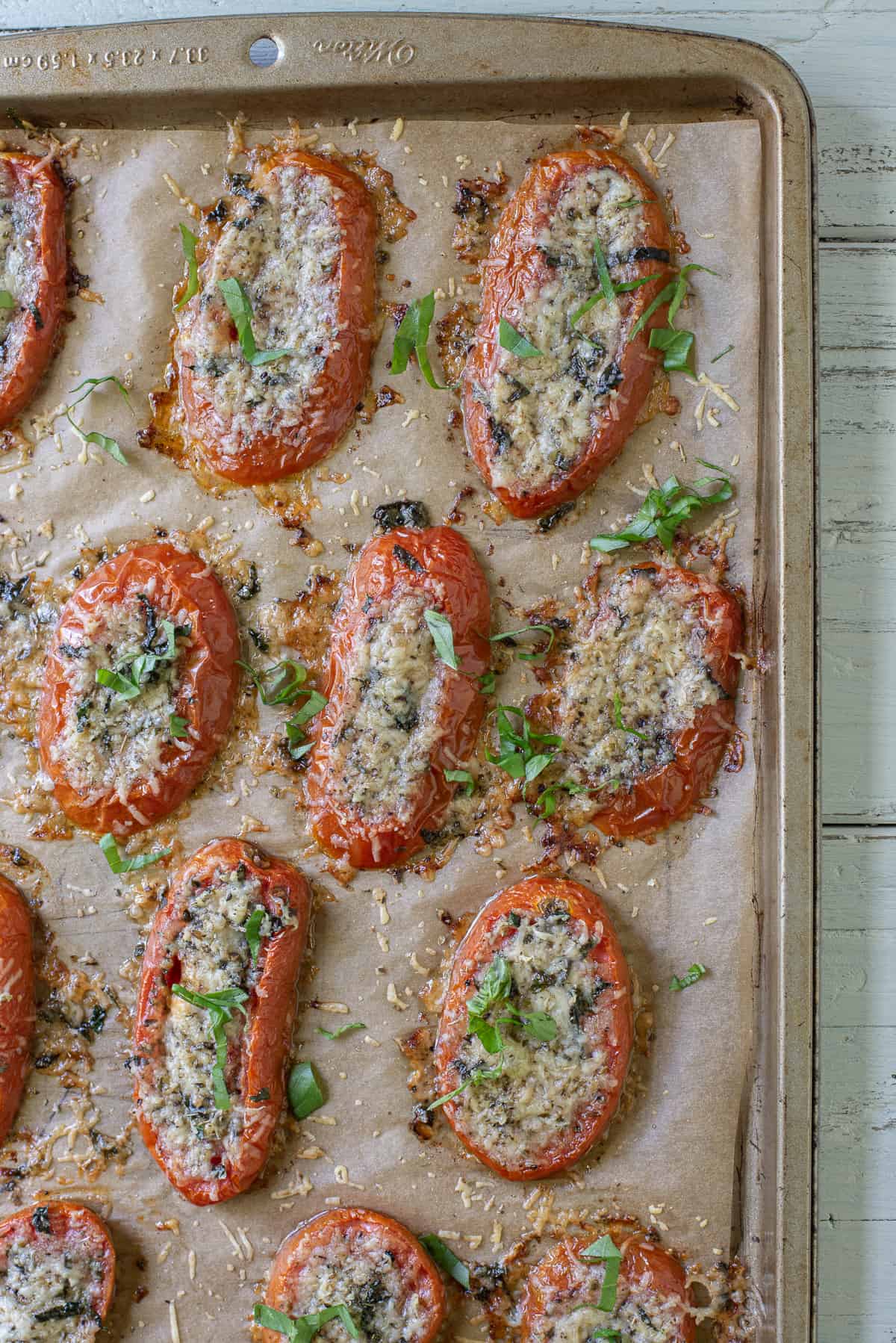 Baked tomato slices with parmesan on baking sheet