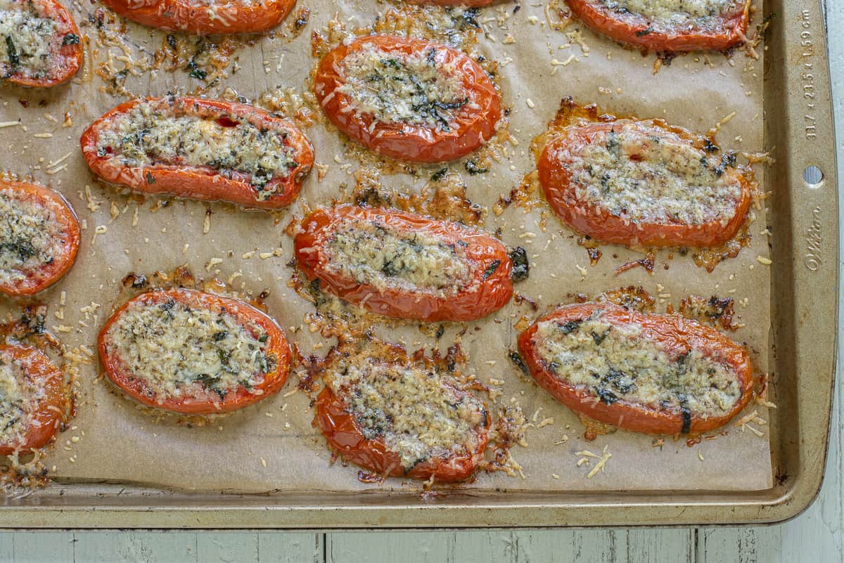 Baked tomato slices with parmesan on baking sheet