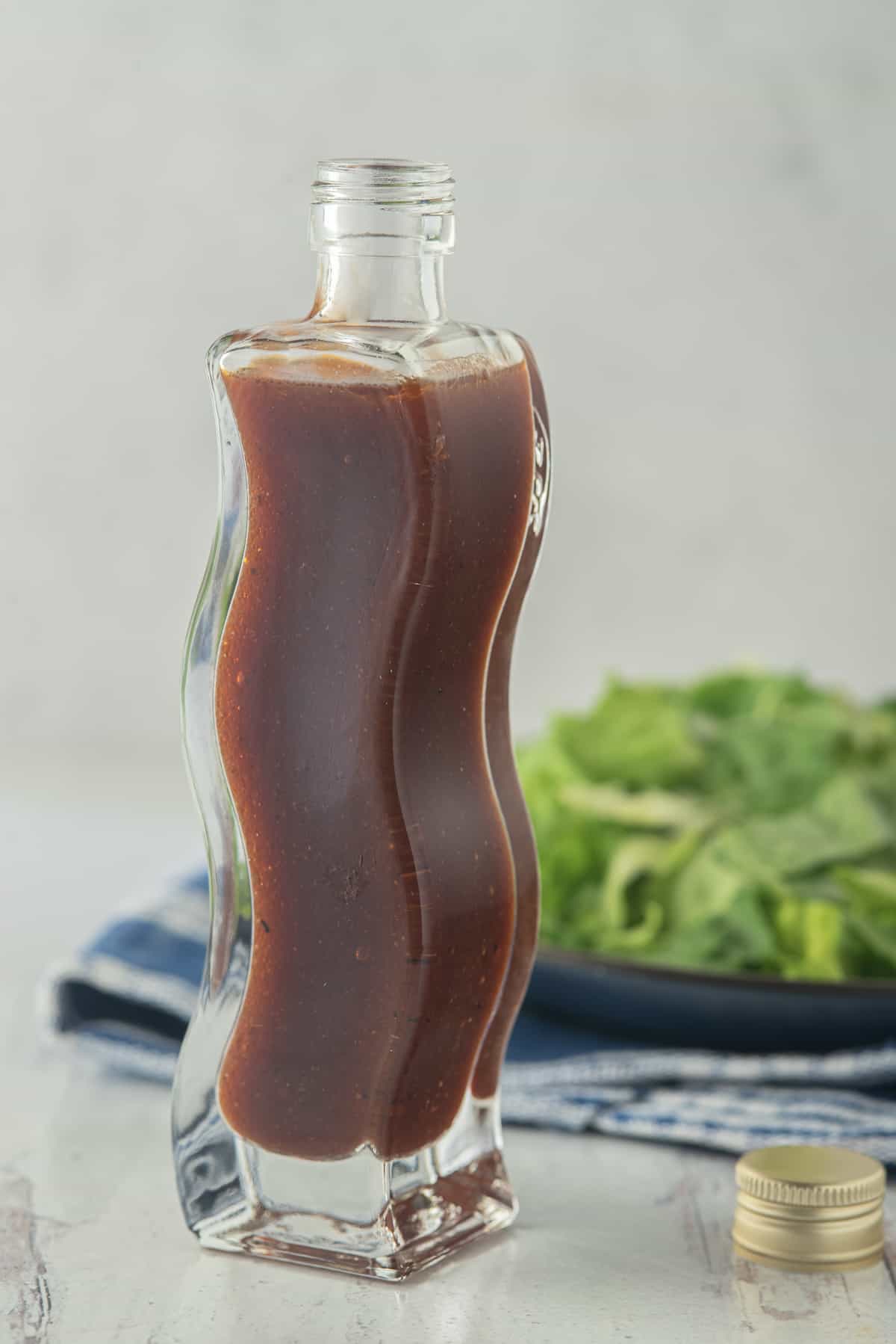 Barbecue Salad Dressing in curved bottle with salad in background
