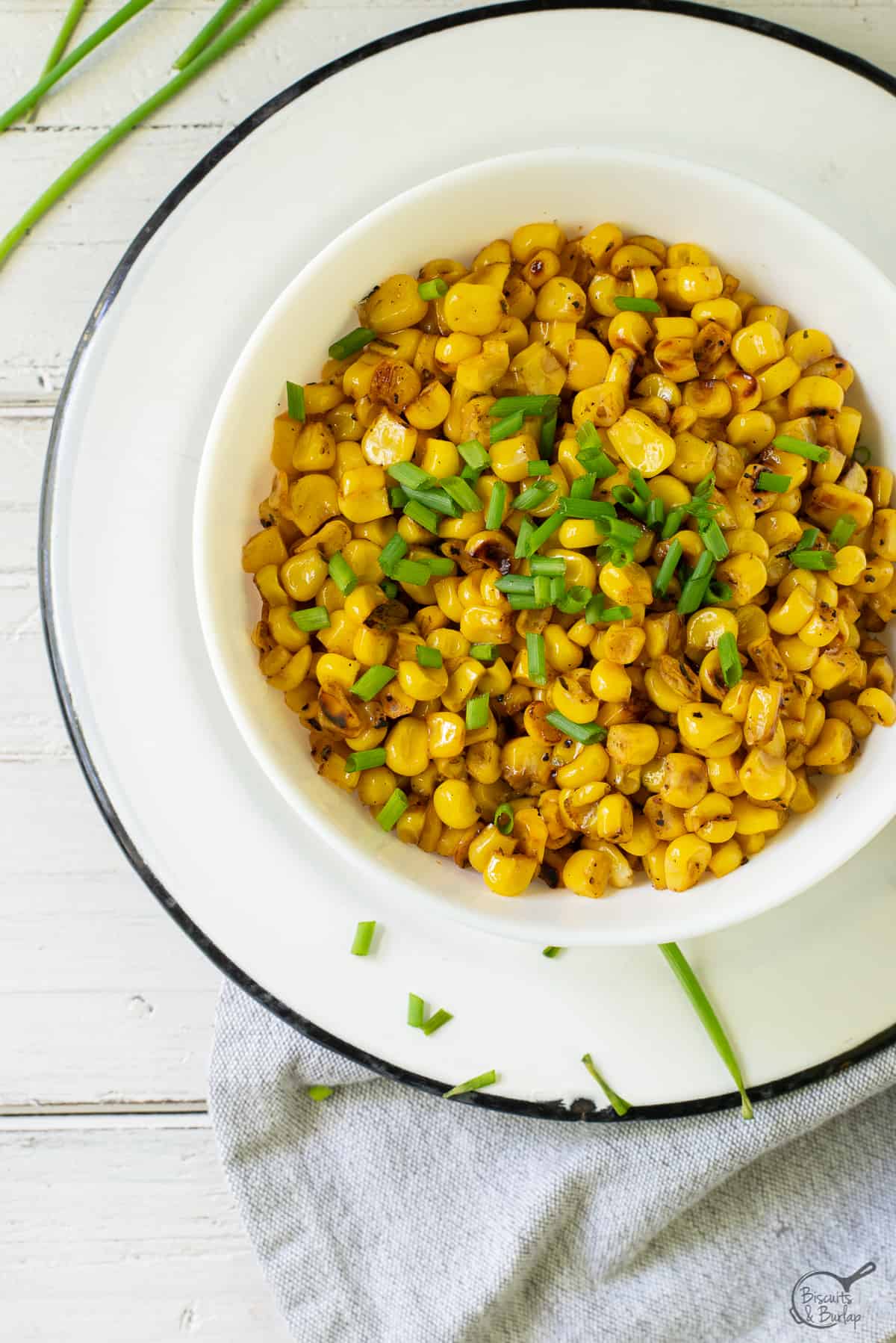 bowl of blackened corn with green garnish.