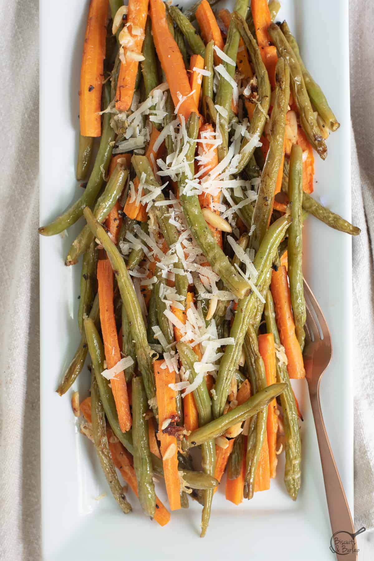 roasted green beans and carrots on white platter