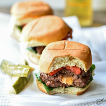 square image of cheese burger sliders with bite out.