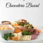 simple charcuterie board on white platter on white background with text overlay