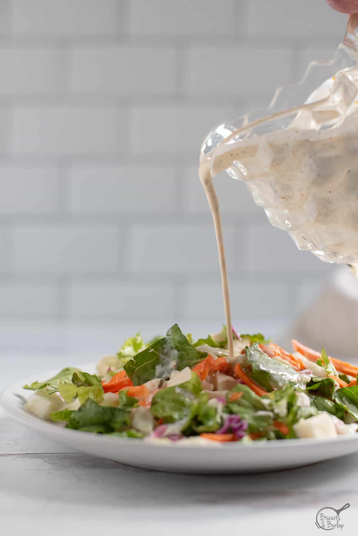 Salad on plate with Creole salad dressing being poured on