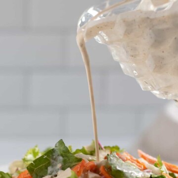 Salad on plate with Creole salad dressing being poured on