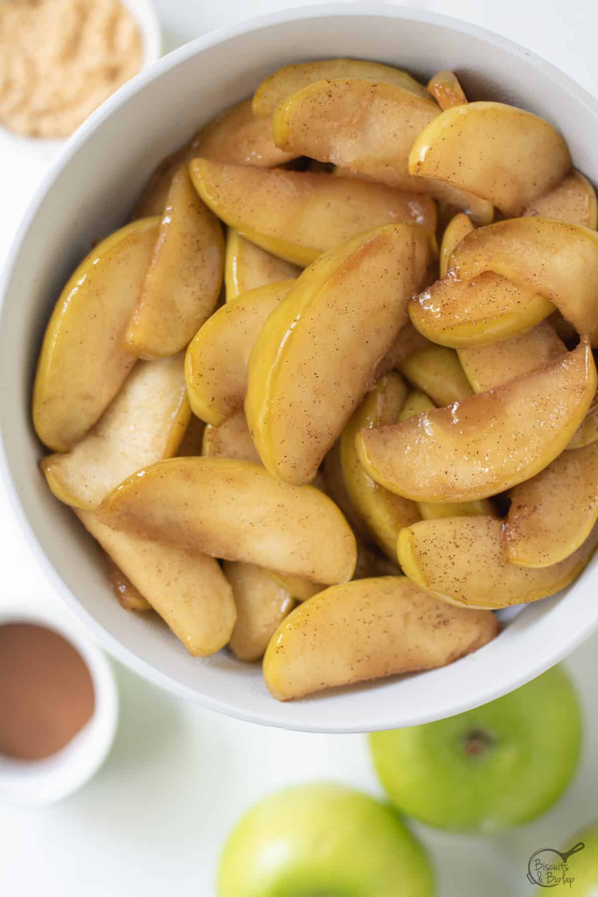 bowl of pan fried apples with ingredients underneath