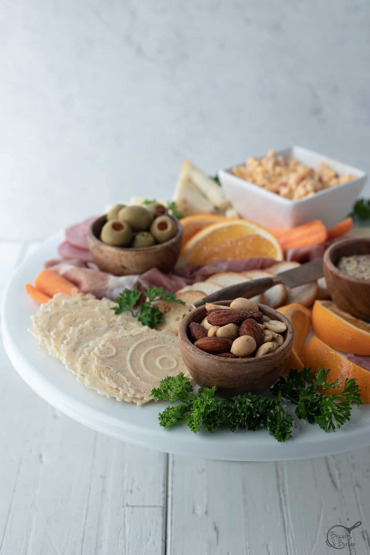 simple charcuterie board on white platter on white background