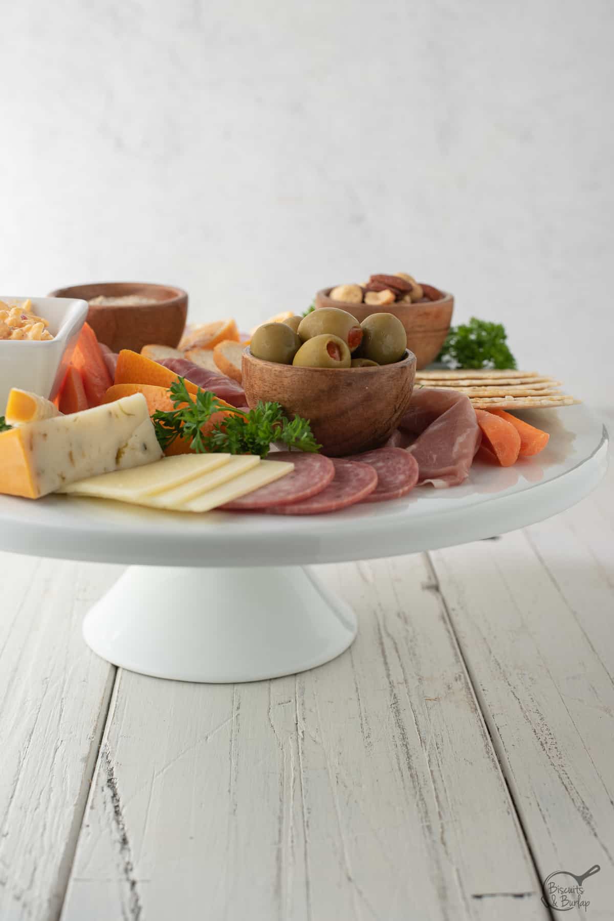 simple charcuterie board on white platter on white background