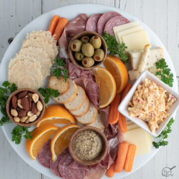 simple charcuterie board on white platter on white background