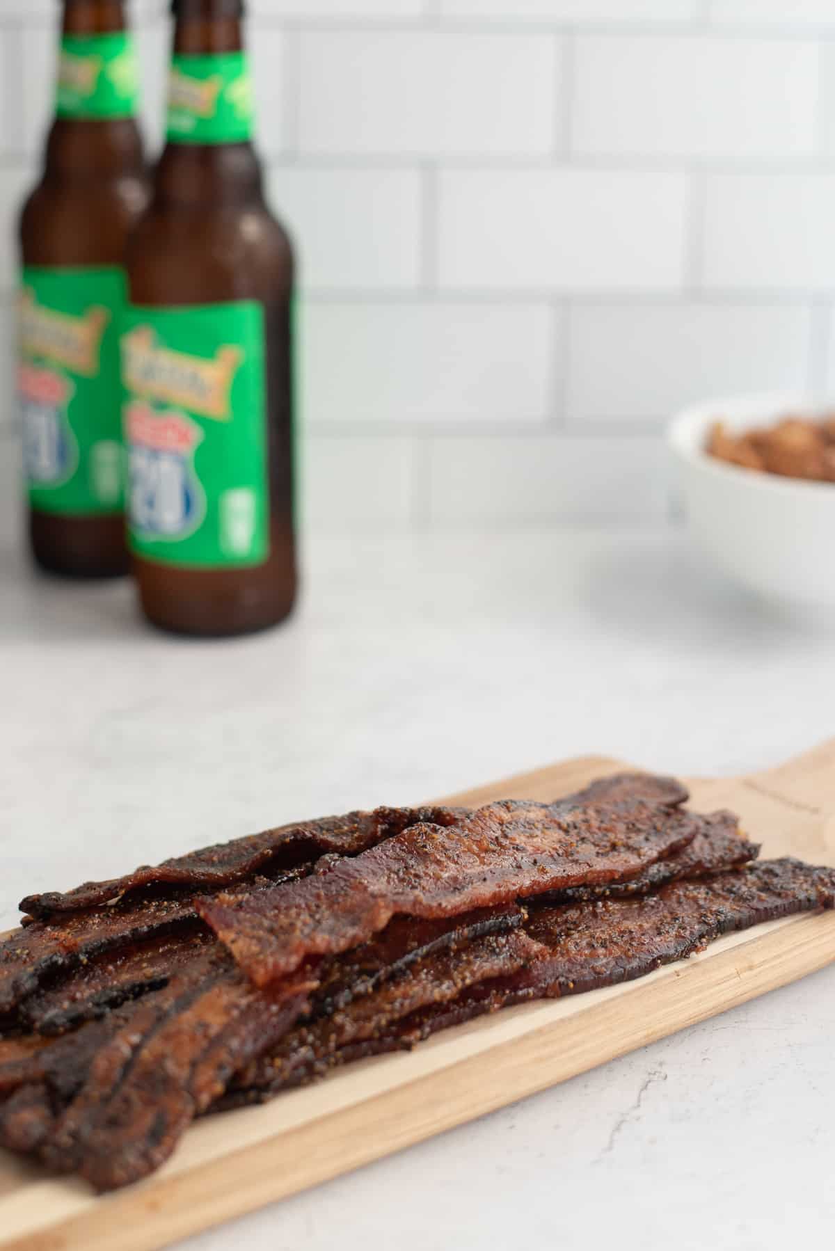 strips of pig candy with beer and nuts behind.