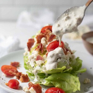 gorgonzola dressing being spooned over salad.