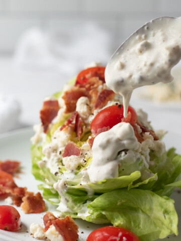gorgonzola dressing being spooned over salad.