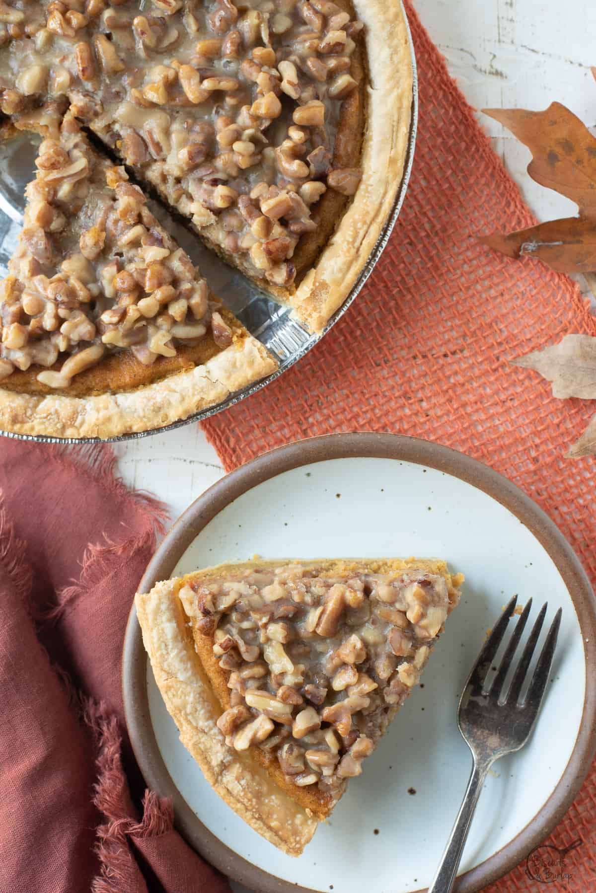 sweet potato praline pie slice on white plate with fork and whole pie