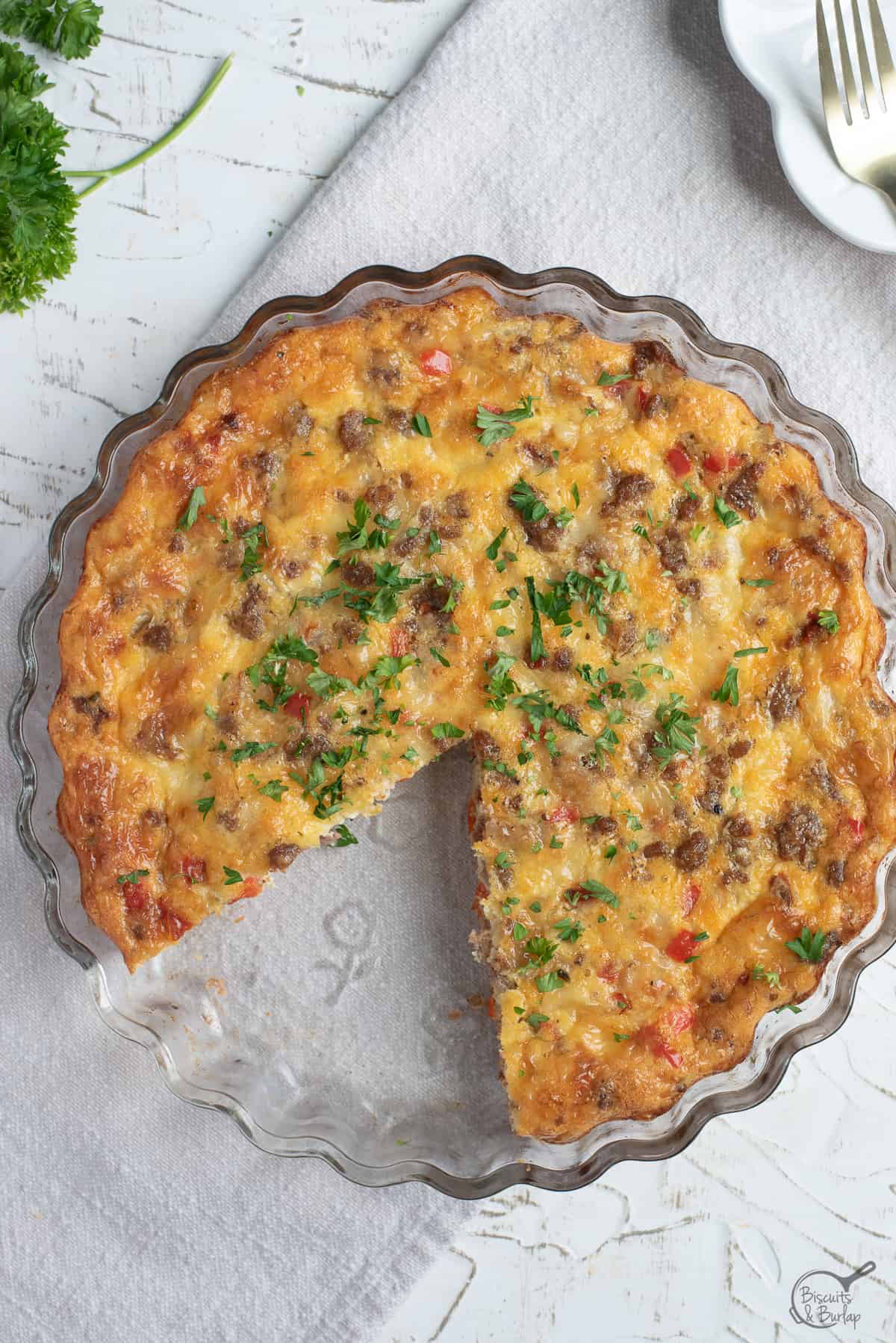 Crustless breakfast quiche with slice missing on white background