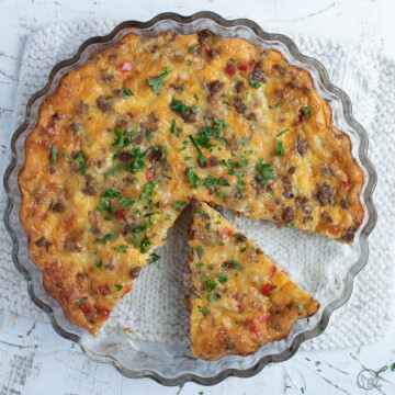 Crustless breakfast quiche with slice cut on white background