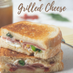 Groumet Grilled cheese, sliced in half on white plate with text overlay