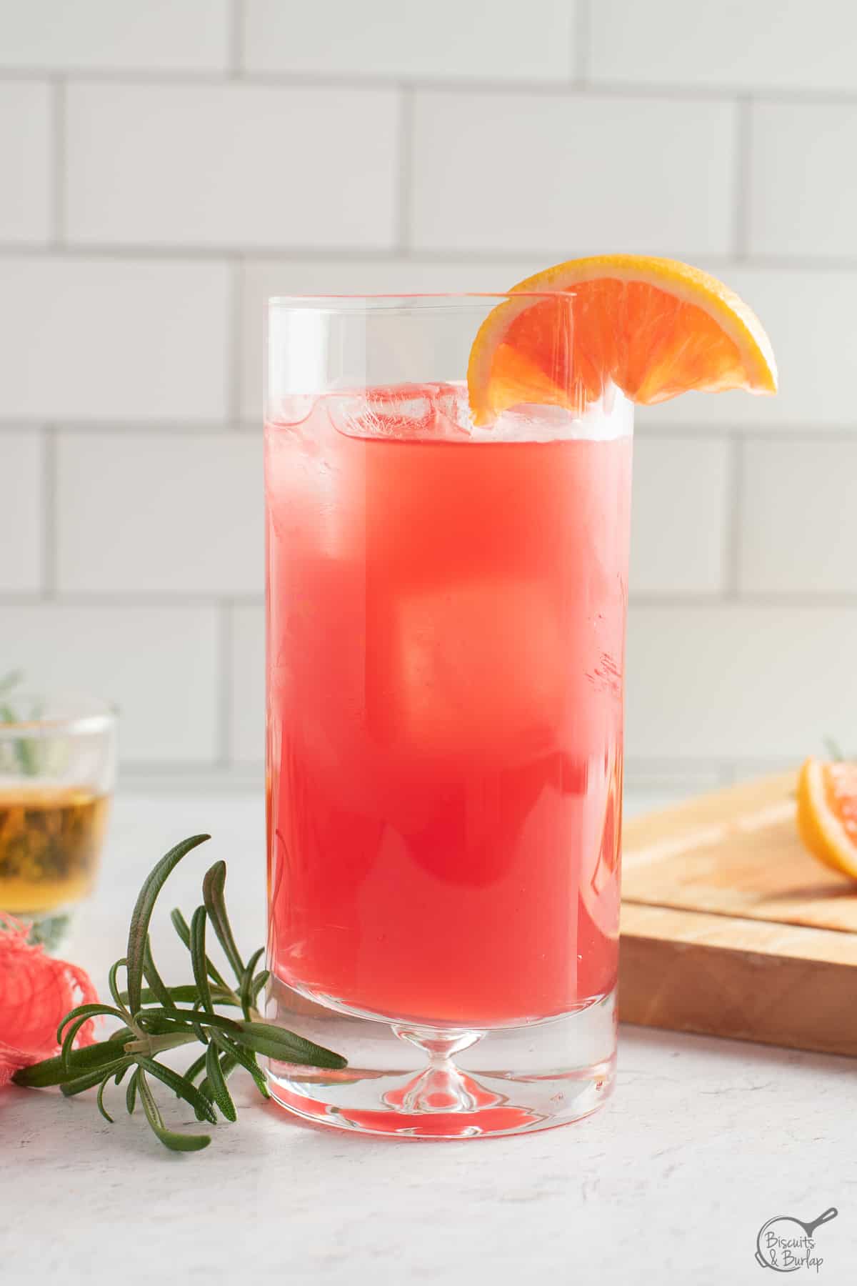 one cocktail made with blood orange and bourbon in glass.