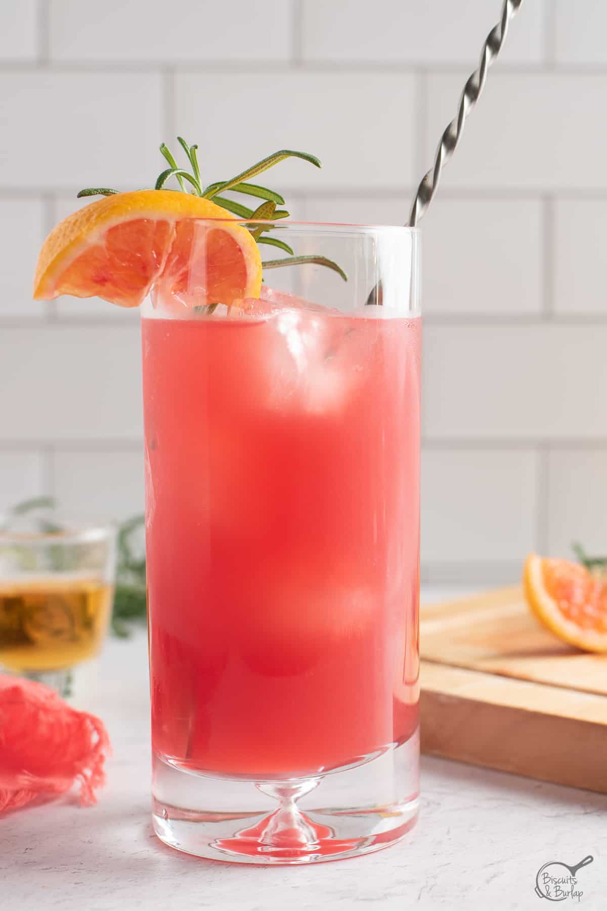 cocktail with blood orange and bourbon in glass with spoon. 