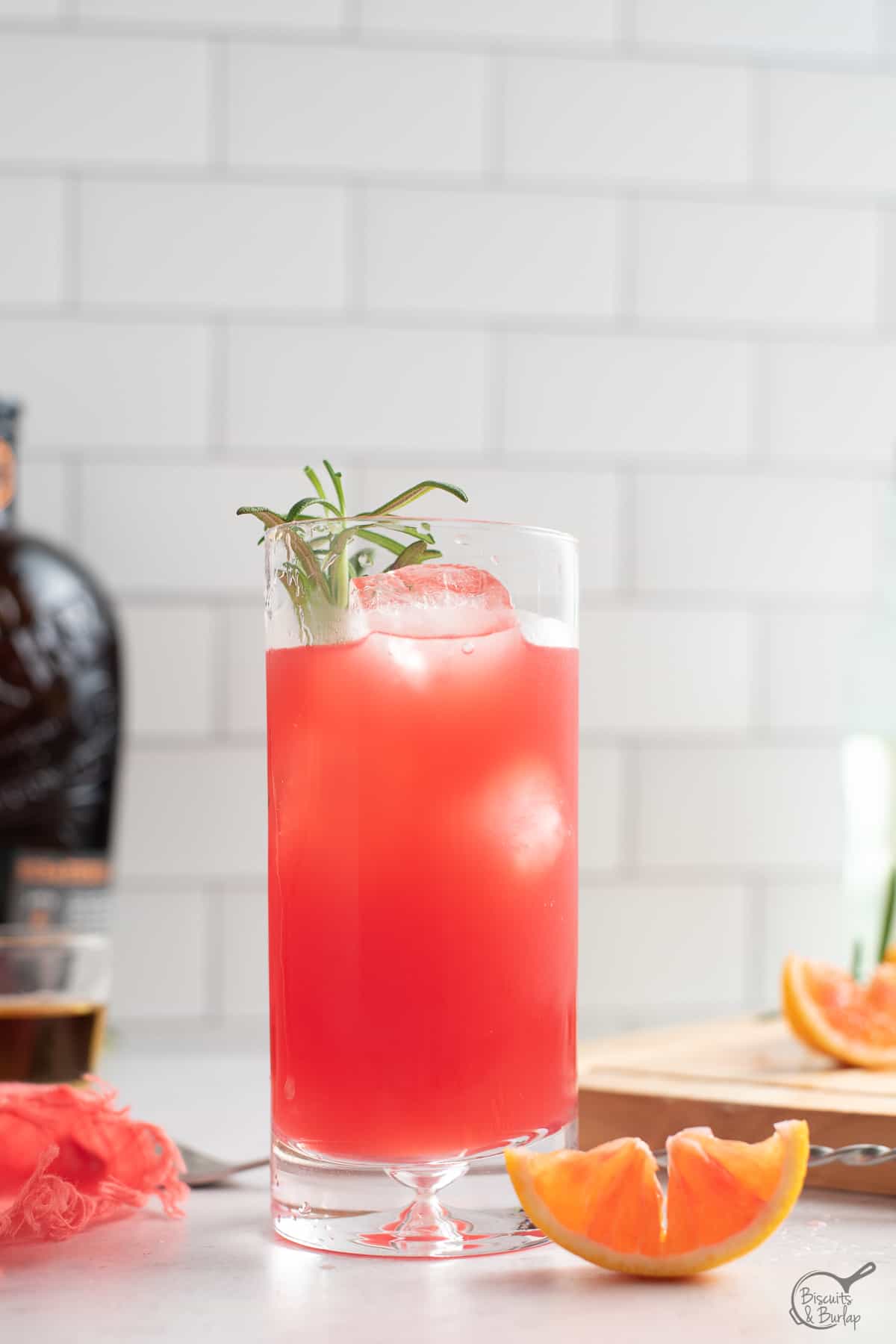 bourbon cocktail with blood orange and bourbon in background. 