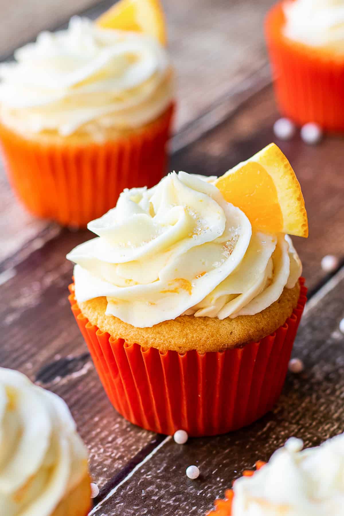 orange cupcakes with more behind.
