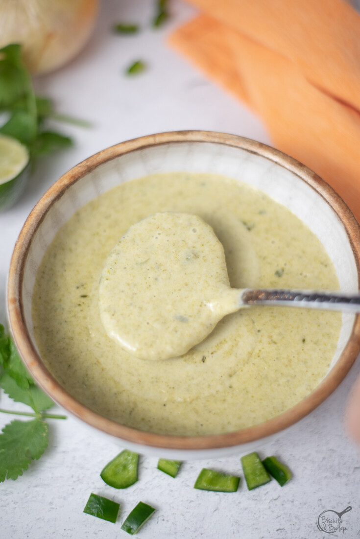 a spoonful of poblano sauce over bowl.