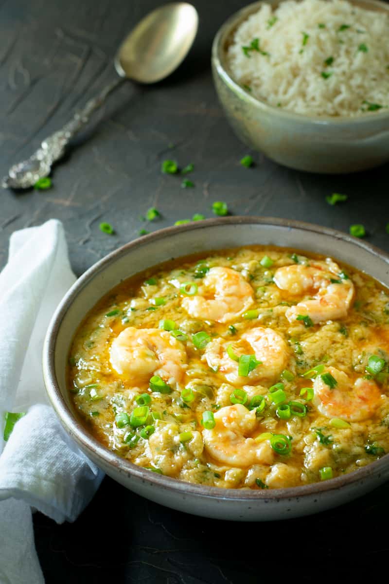 bowl of shrimp etouffee with napkin and spoon.