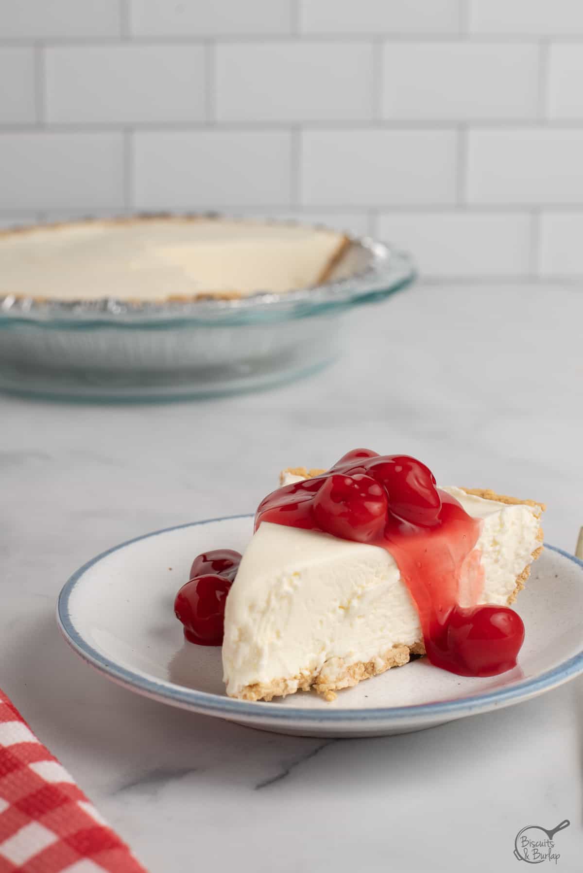 slice of no bake cheesecake with whole one behind. 