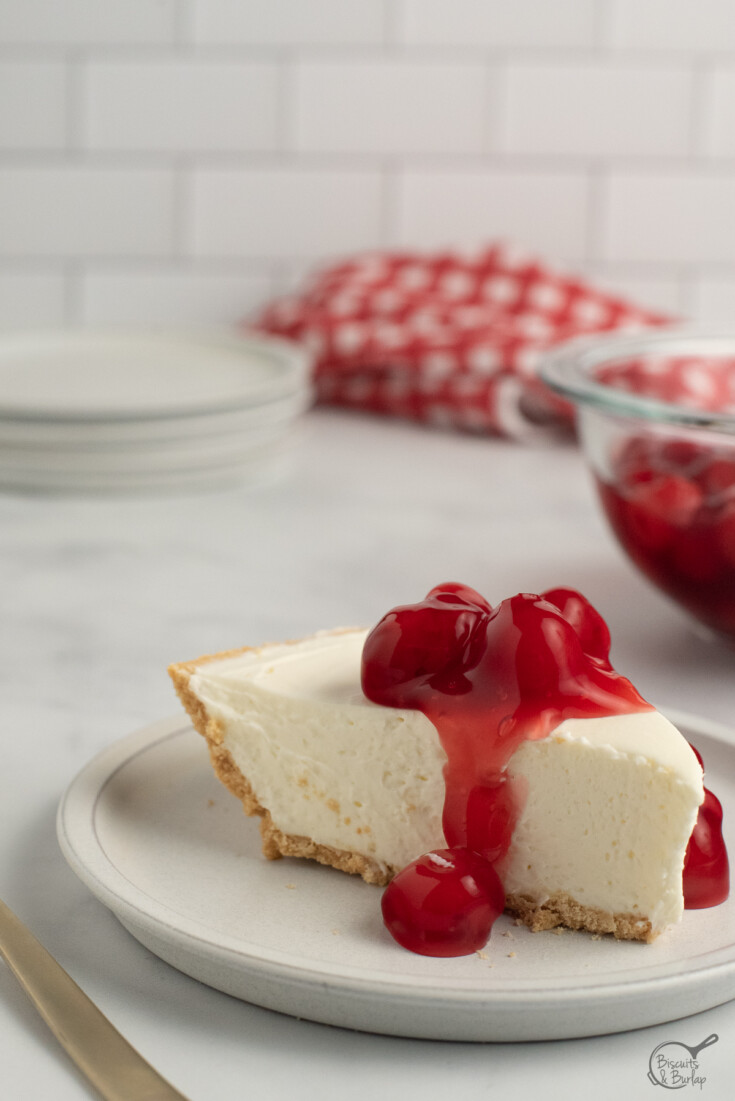 slice of 3 ingredient cheesecake with cherry topping.