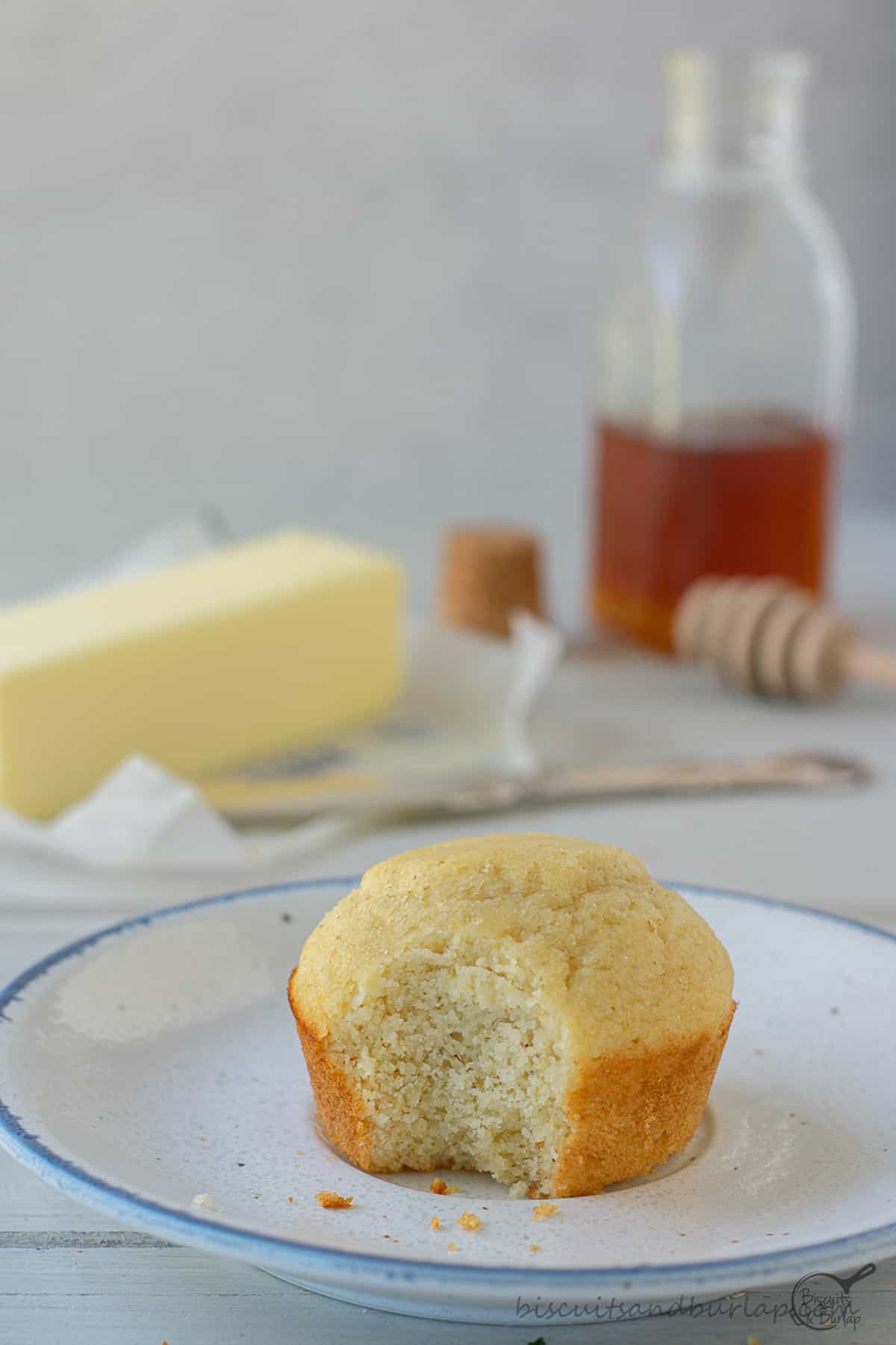 buttermilk cornbread muffin on plate with bite out. 