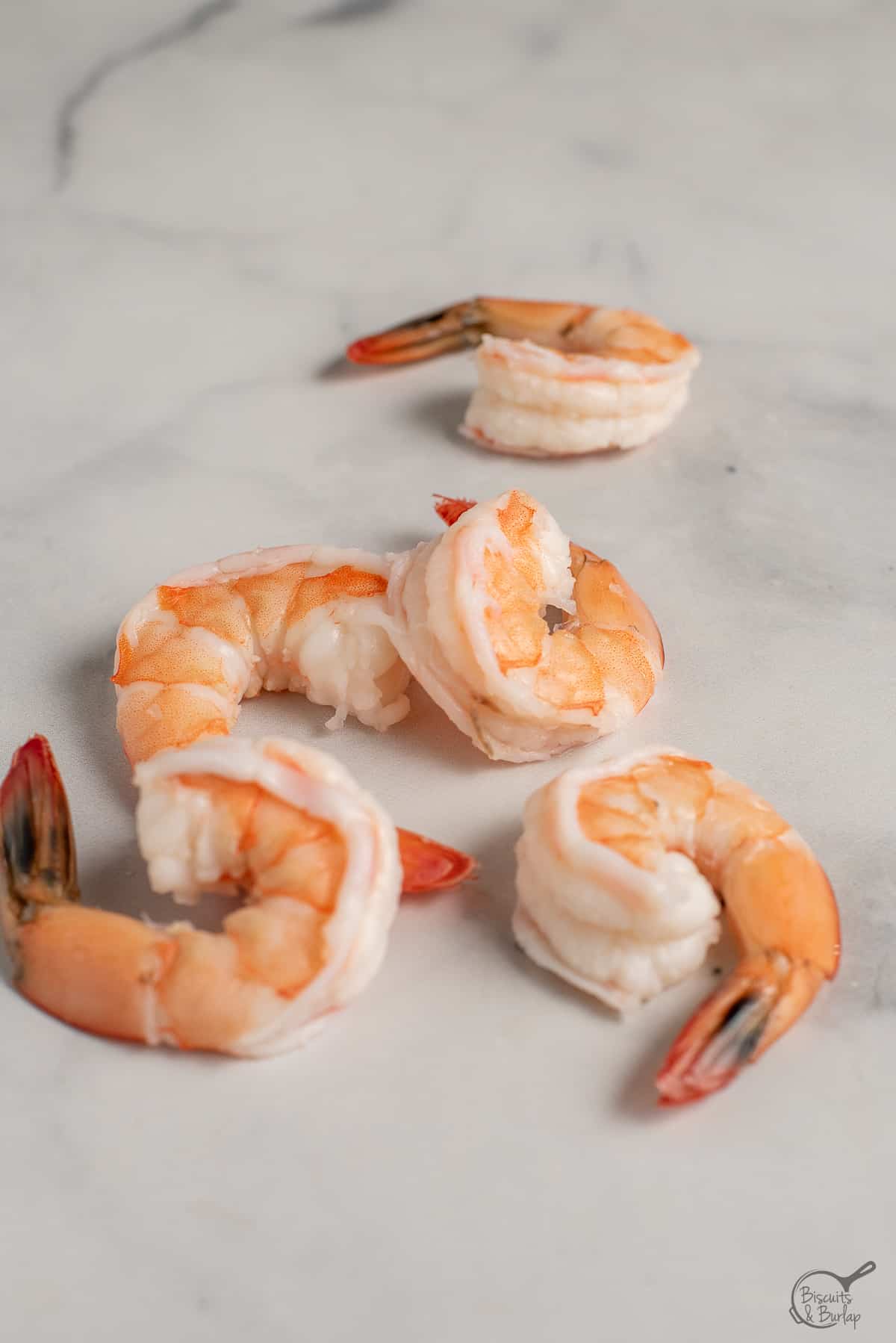 cooked shrimp that is peeled and deveined but with tails on.