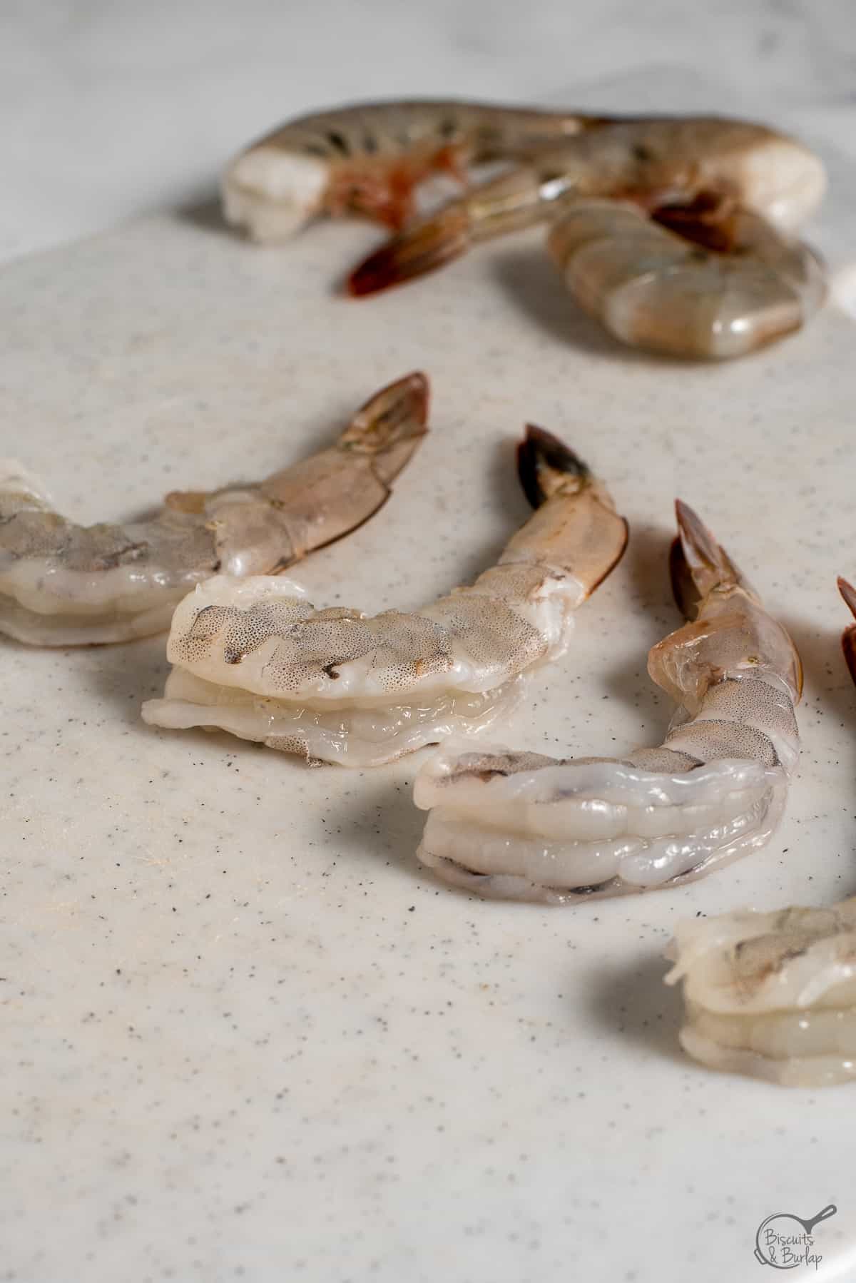 raw peeled shrimp with tails on.