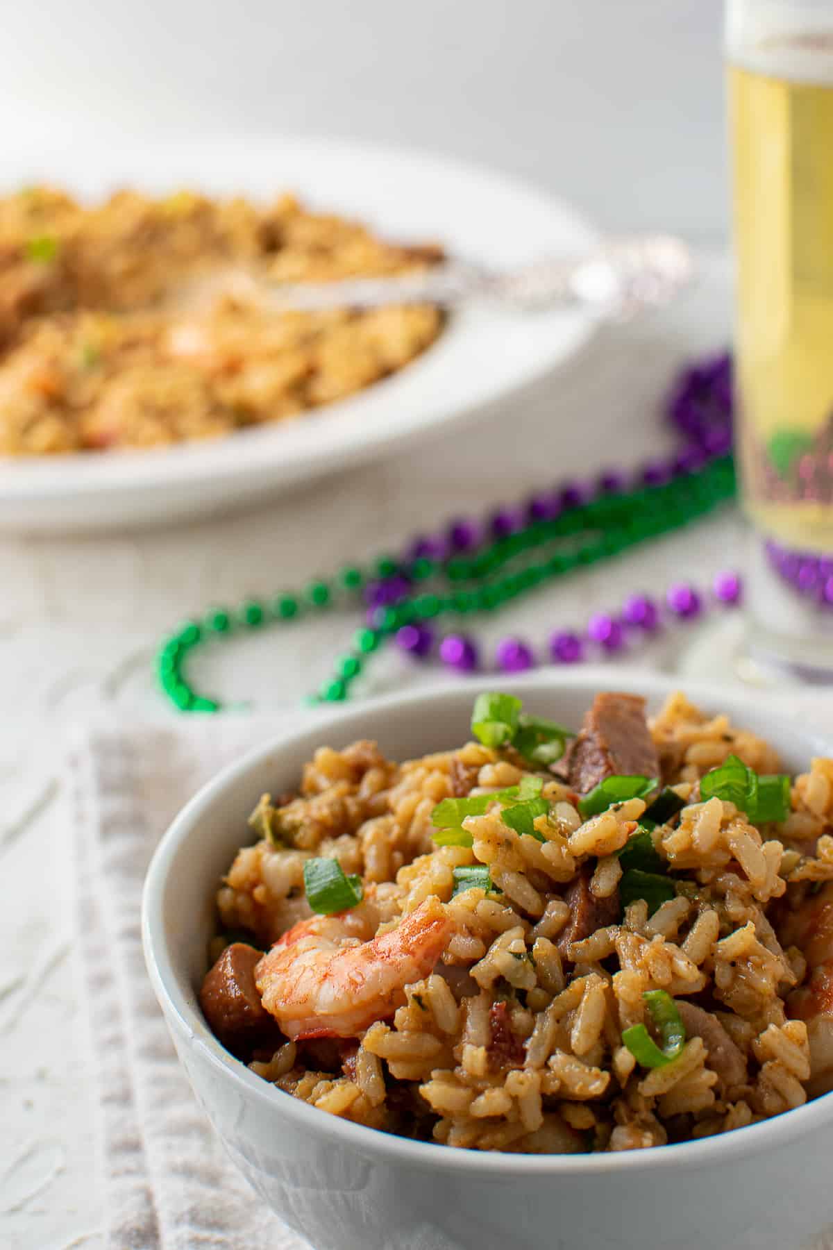 small bowl of the best jamabalaya with mardis gras beads.