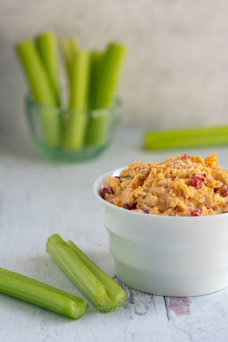 white bowl with pepper jack pimento cheese and celery.