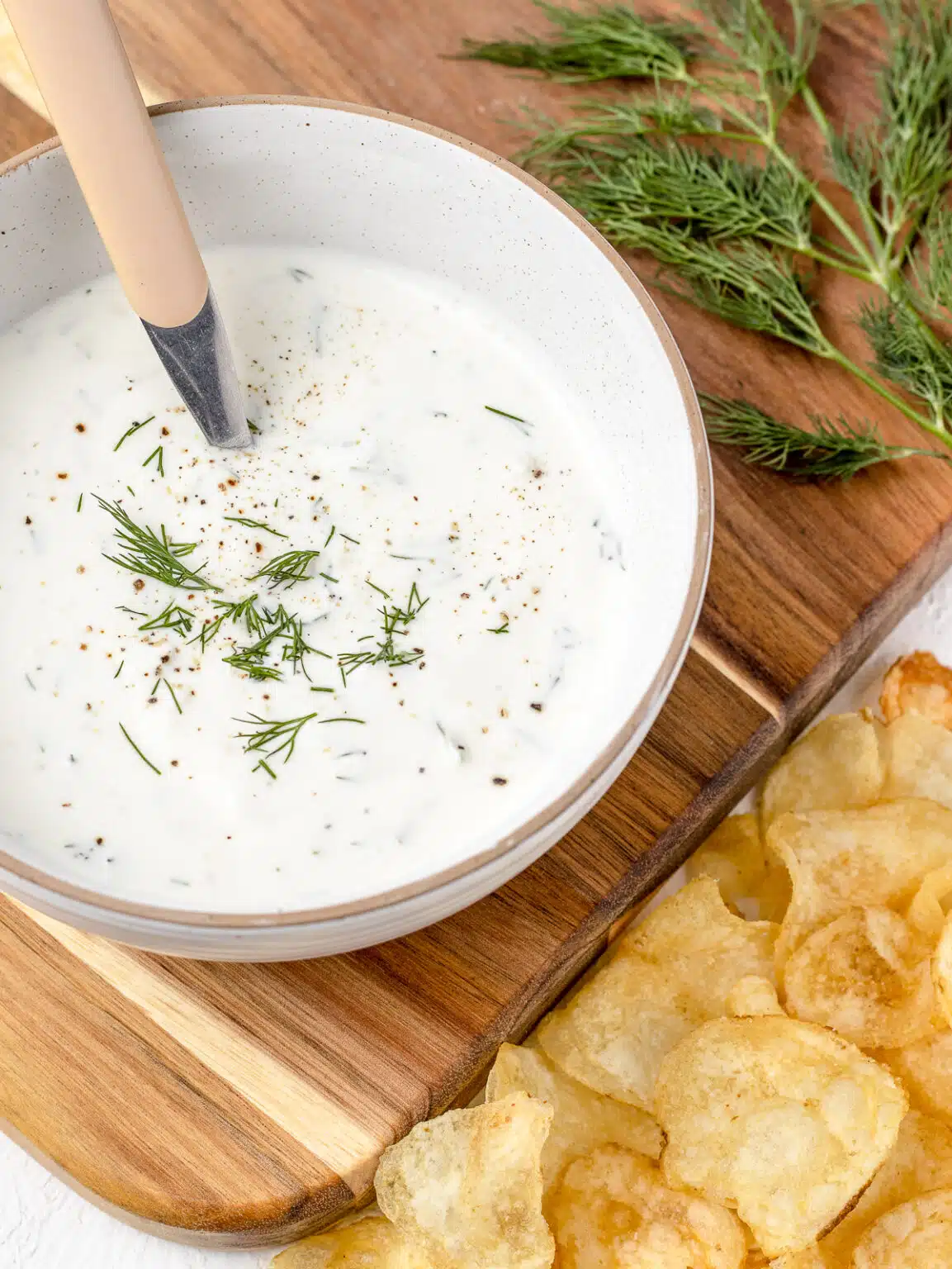 yogurt dill sauce in bowl on board. 