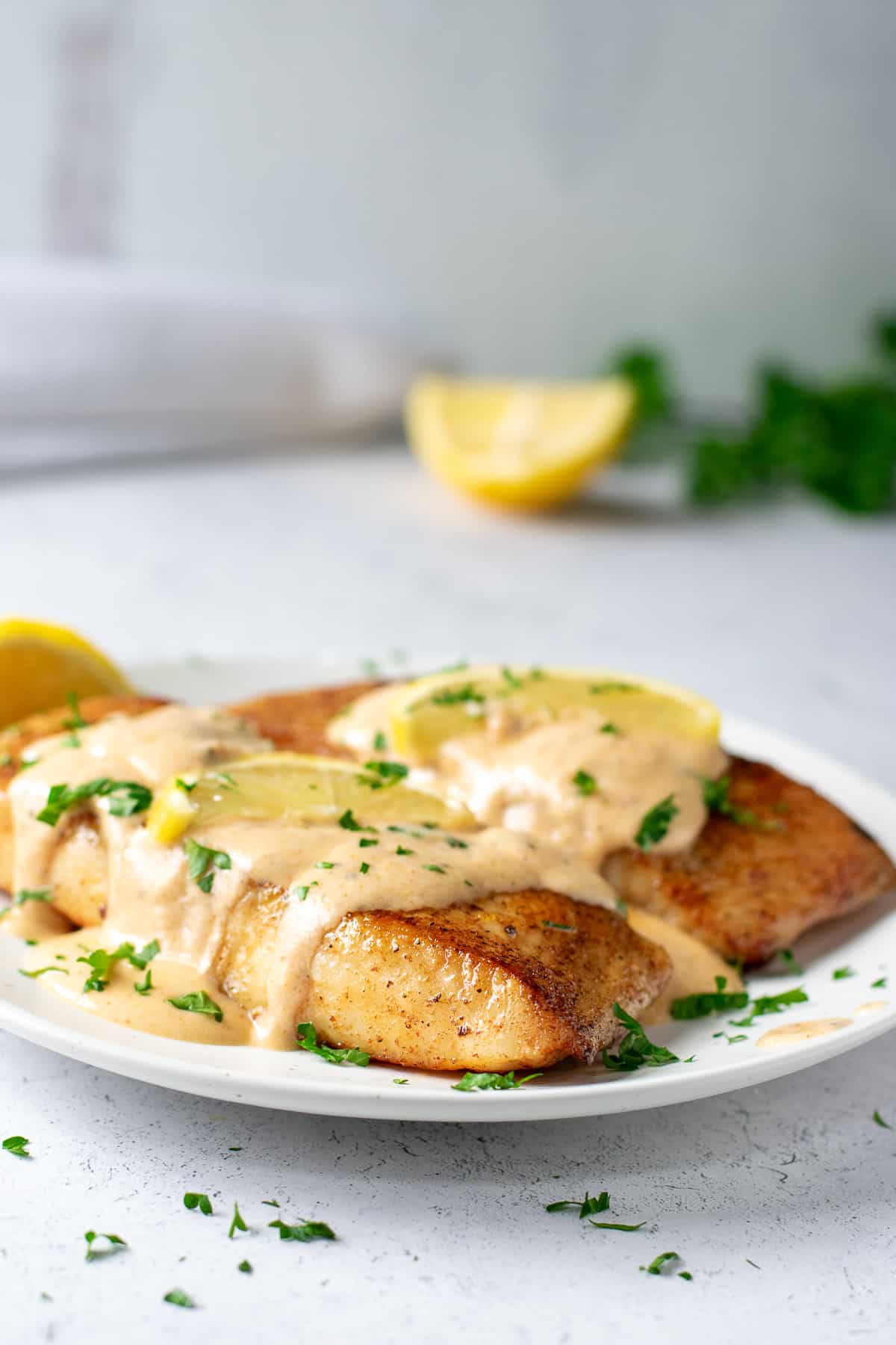 two filets of fish topped with Cajun cream sauce.