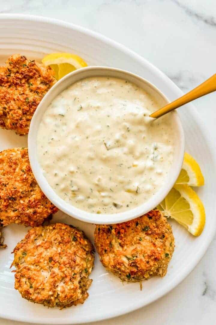 bowl of tartar sauce with fried food and lemons. 