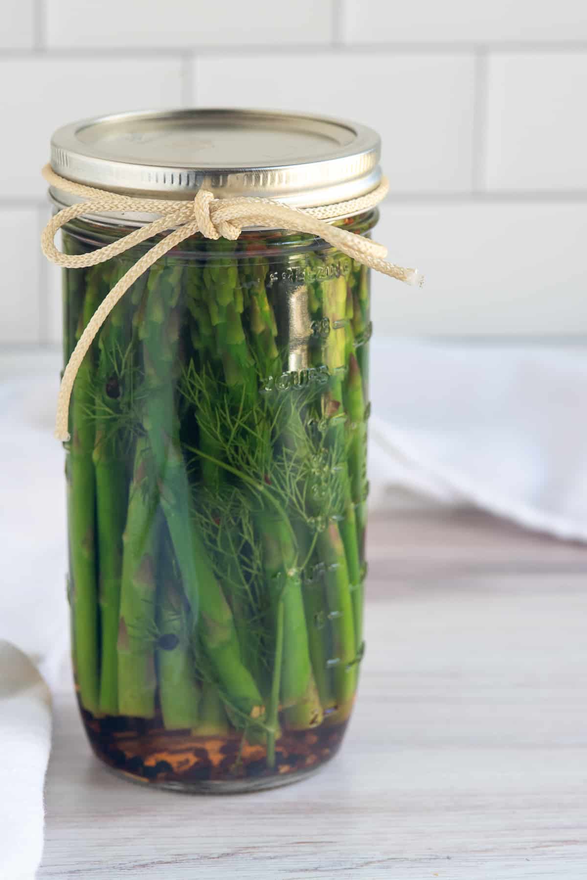 jar of pickled asparagus with bow.