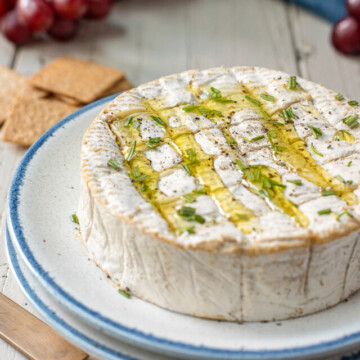camembert with scored top and herbs.