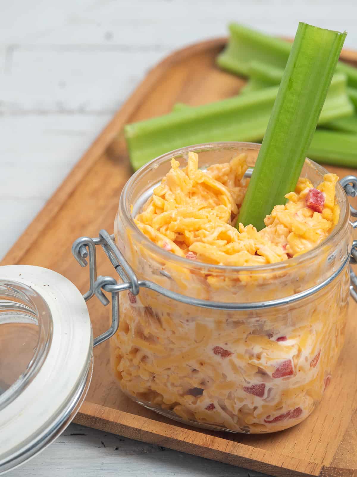 jar of pimento cheese with celery stick. 