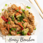 Honey bourbon chicken on white plate with title in text overlay