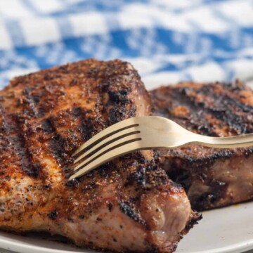 blackened chops being pierced with a fork.