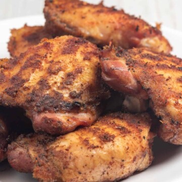 smoked chicken piled up on plate.