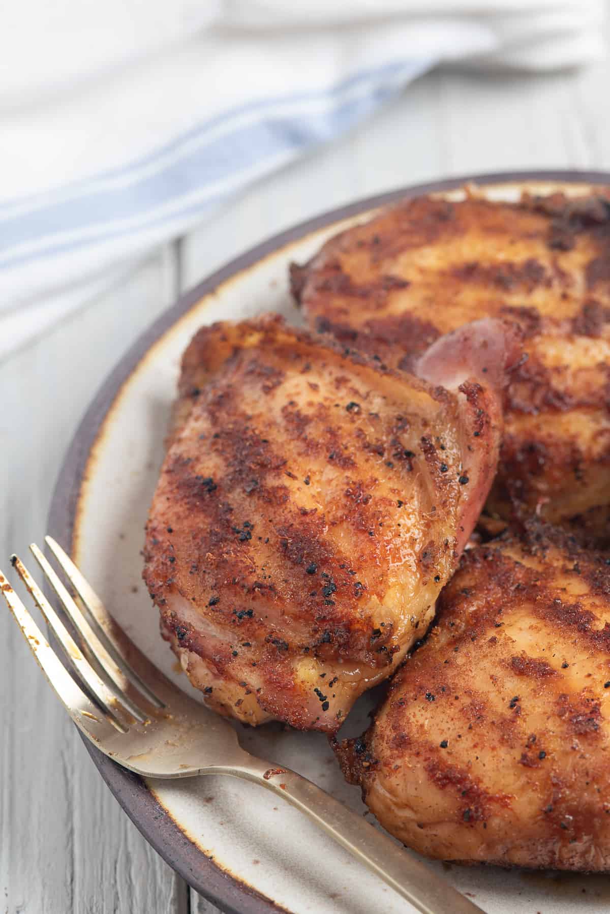 smoked chicken thighs on plate with fork.