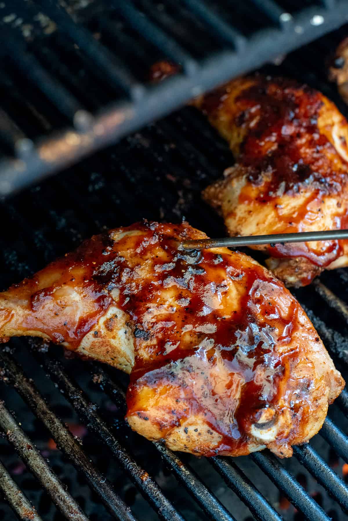 quarter chickens on grill with thermometer probe.