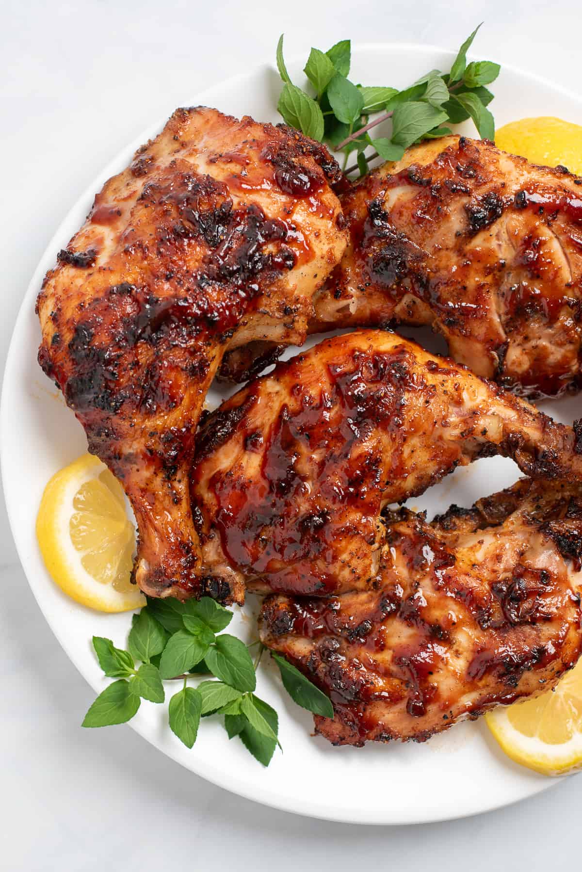grilled chicken leg quarters on a plate. 