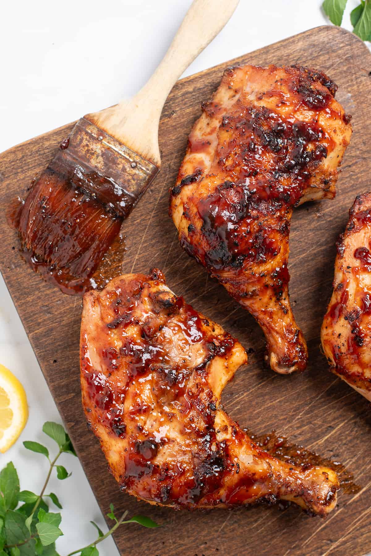 grilled quarter chicken on board with brush.