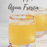 Pineapple Agua Fresca in a lowball glass with a Tajin rim and recipe title in text overlay