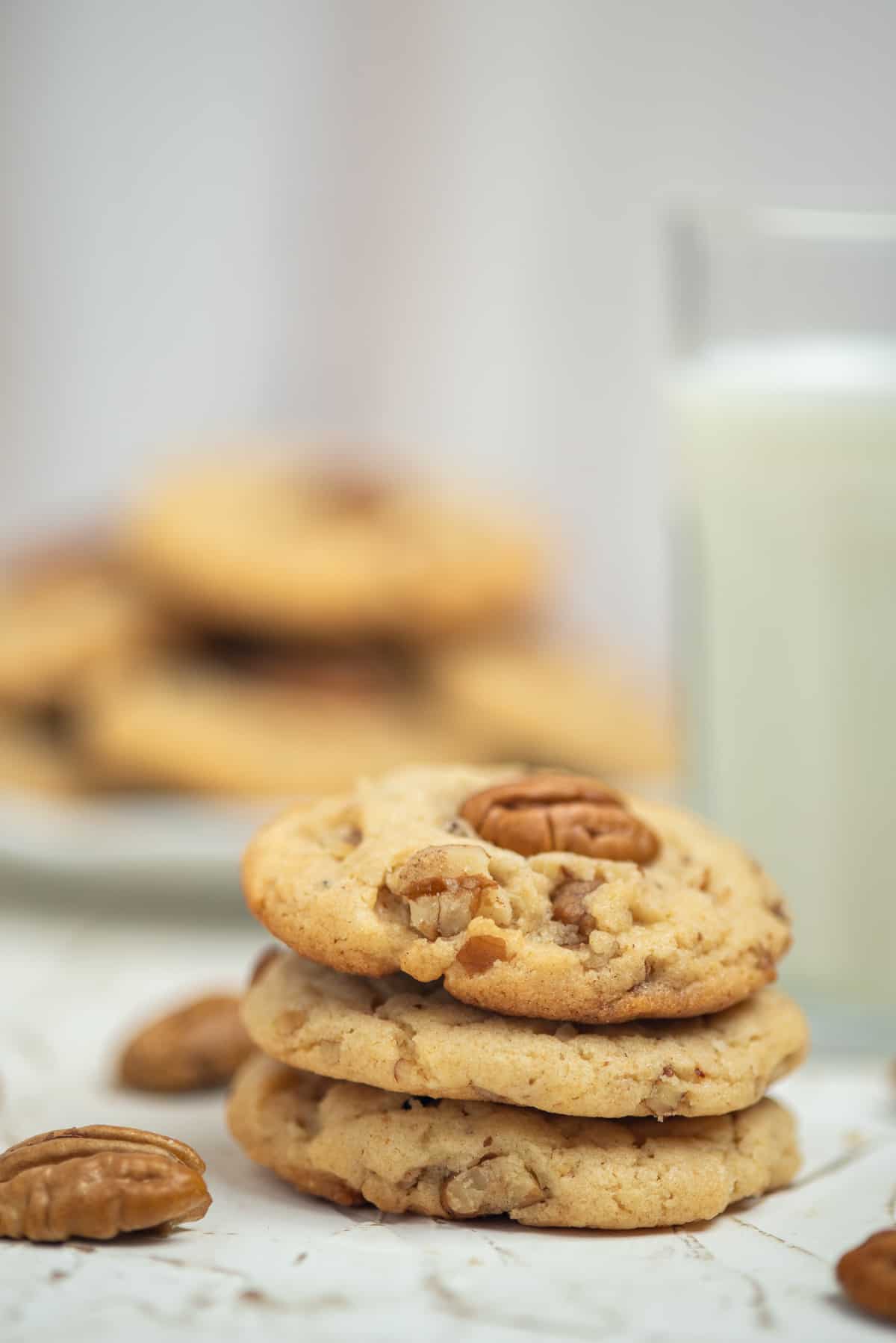 stack of 3 brown butter pecan cookies with milk.